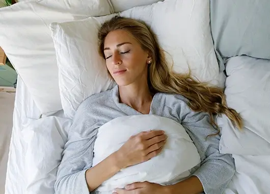Une femme allongée dans un lit dort paisiblement.