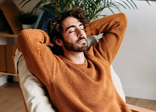 Un homme est installé confortablement dans un fauteuil.