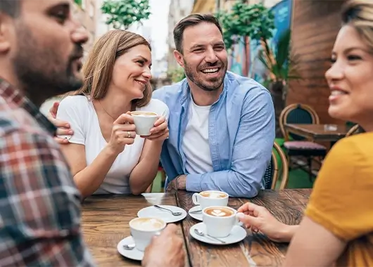 Un groupe d'amis partage un moment joyeux en terrasse.