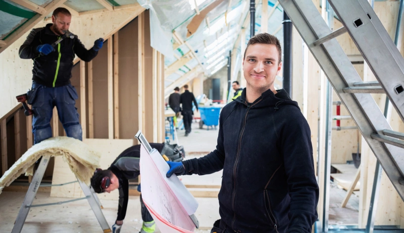Personne tenant un plan sur un chantier